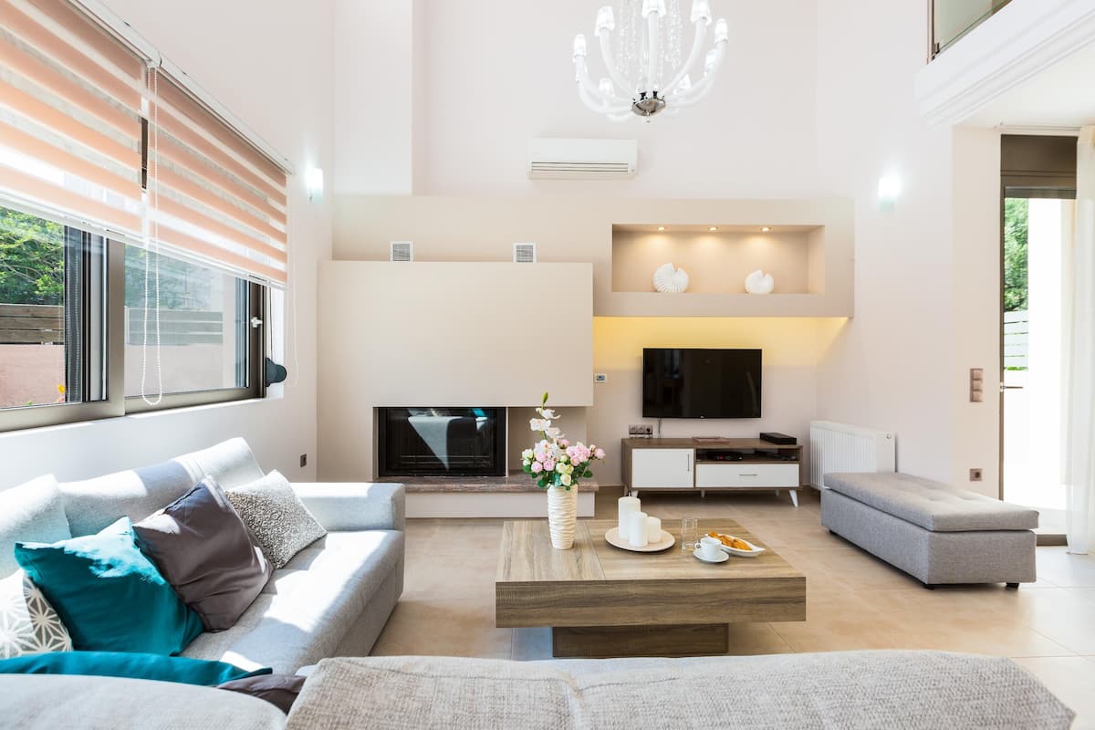 Uma sala de estar moderna com sofá, mesa de centro e televisão.