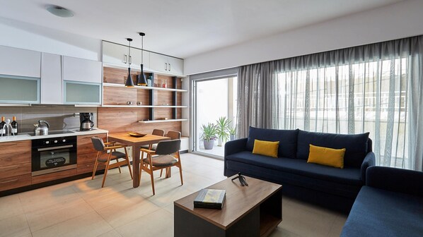 A modern kitchen with wooden cabinets, a dining area with a table and chairs, and a living room with a sofa and a coffee table.