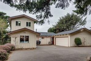 A two-story house with a garage, a covered porch, and a driveway.