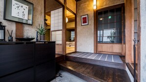 Een traditioneel Japans interieur met tatami vloeren, een houten receptiebalie en een schuifdeur.