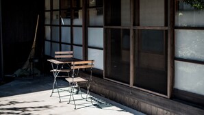 Een traditionele Japanse kamer met tatami-matten, een lage houten tafel en een klapstoel.