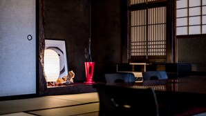 Una habitación japonesa tradicional con suelo de tatami, una mesa baja y una puerta corredera.