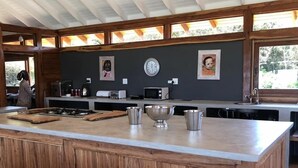 Una cocina moderna con una isla grande de madera, electrodomésticos de acero inoxidable y vistas al exterior.