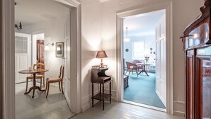 A hallway with a dining area, featuring a table and chairs, a lamp, and a door leading to another room. - Romantisch wohnen in Kaub am Rhein (Kaub)