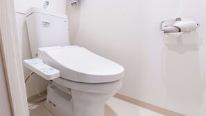Moderni wc, jossa on ohjauspaneeli ja seinään asennettu bidee.