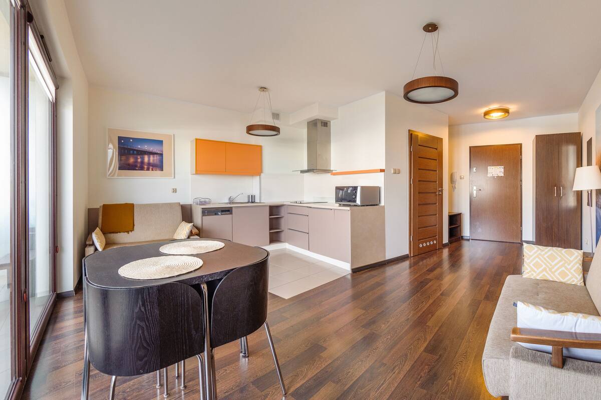 A modern apartment with a dining area, kitchen, and living room.