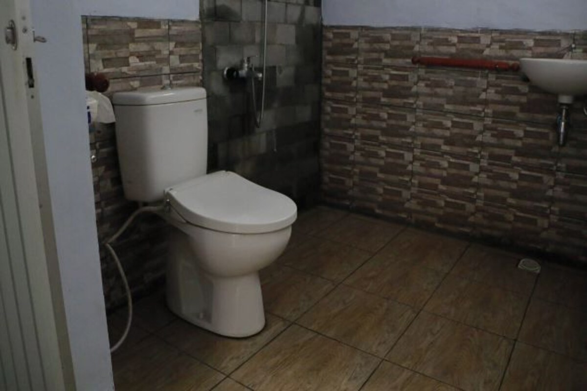 A bathroom with a toilet, shower, and sink.