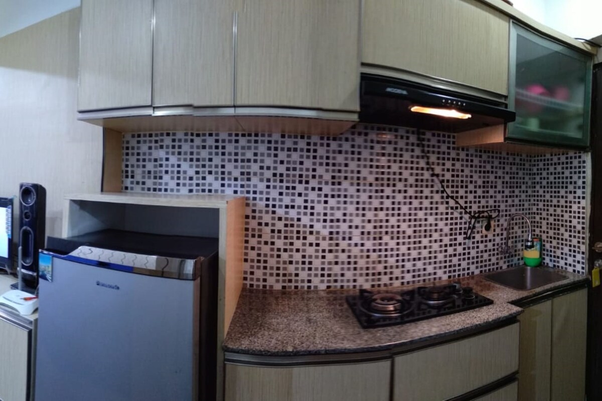 A compact kitchen with a built-in microwave, a gas stove, and a small sink.