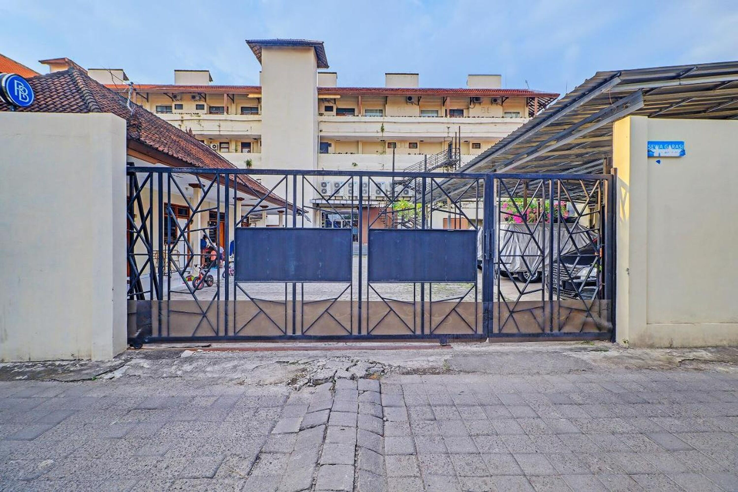 A gated entrance to a building with a tiled roof and a sign indicating 'STWAGGAS'.