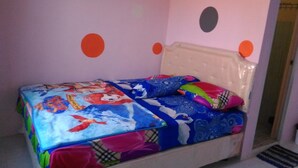 Ein Schlafzimmer mit einem Bett, das mit farbenfroher Bettwäsche bezogen ist, einem Kopfteil und einer Wand mit Punkten.
