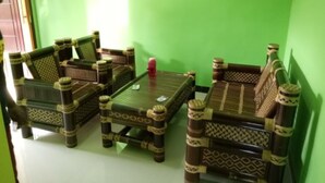 Ein Zimmer mit grünen Wänden und einem traditionellen Sofagarnitur mit Sessel.