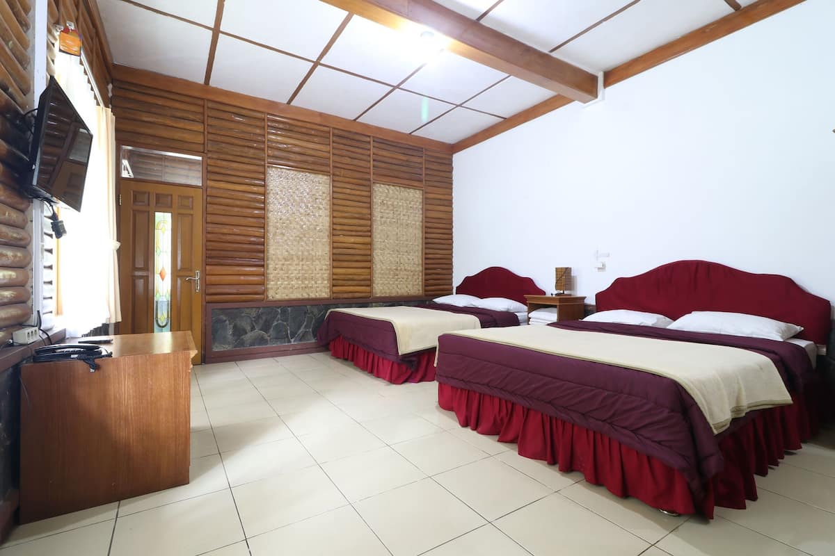 A hotel room with two beds, a wooden desk, and a tiled floor.