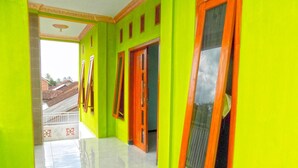 A hallway with bright green walls and orange-framed windows. - Kawah Ijen Homestay (Banyuwangi)