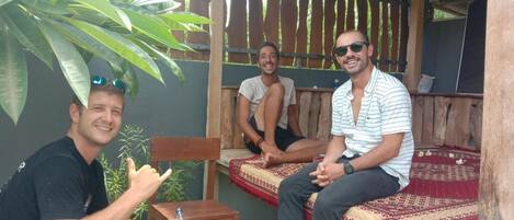A wooden outdoor seating area with a bench and a small table.