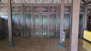 A spacious room with a high ceiling and wooden paneling. - Homestay Ngudi (Mangunan)