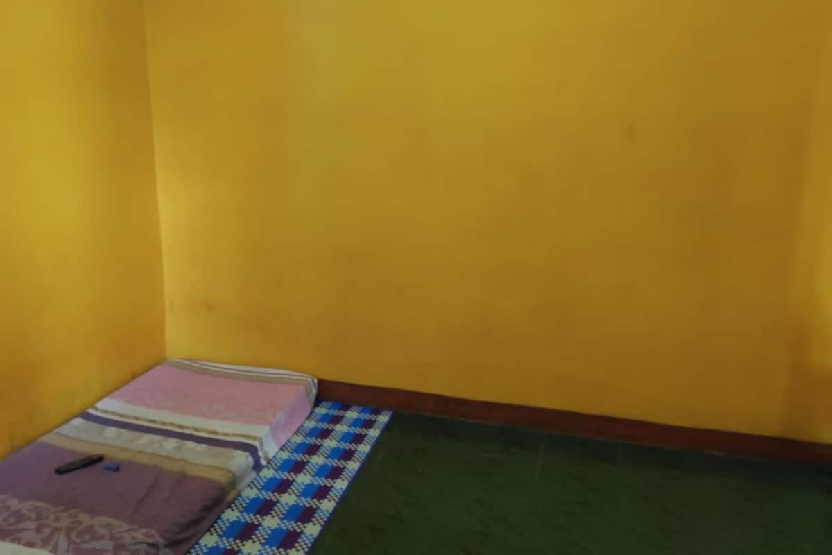 A small room with a bed, a pillow, and a blanket.