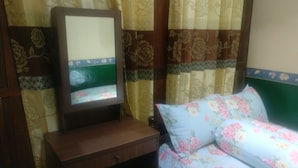 A room with a bed, a wooden nightstand, and a mirror. - Homestay Arya Mangunan (Mangunan)