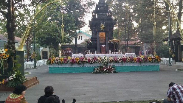 A decorated outdoor area with a stage, floral arrangements, and seating. - Rumah Singgah Peziarah Ganjuran (Sumbermulyo)