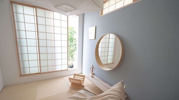 A minimalist bedroom with tatami flooring, a bed, a large window, and a round mirror. - Starry Night Dreams of Stars House (Tokyo)