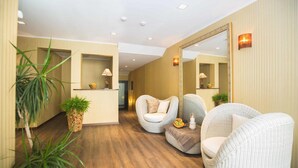 A reception area with a wooden floor, a reception desk, and two wicker chairs. - Hotel Bären (Rupperswil)