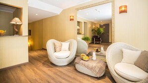 A modern hotel lobby with wicker furniture, a large mirror, and a reception desk. - Hotel Bären (Rupperswil)