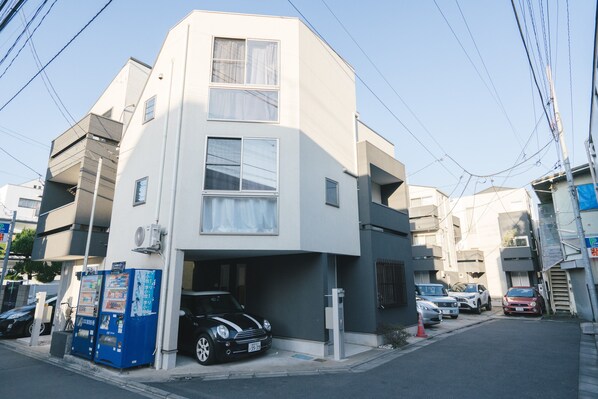 A modern two-story building with a garage parking space.