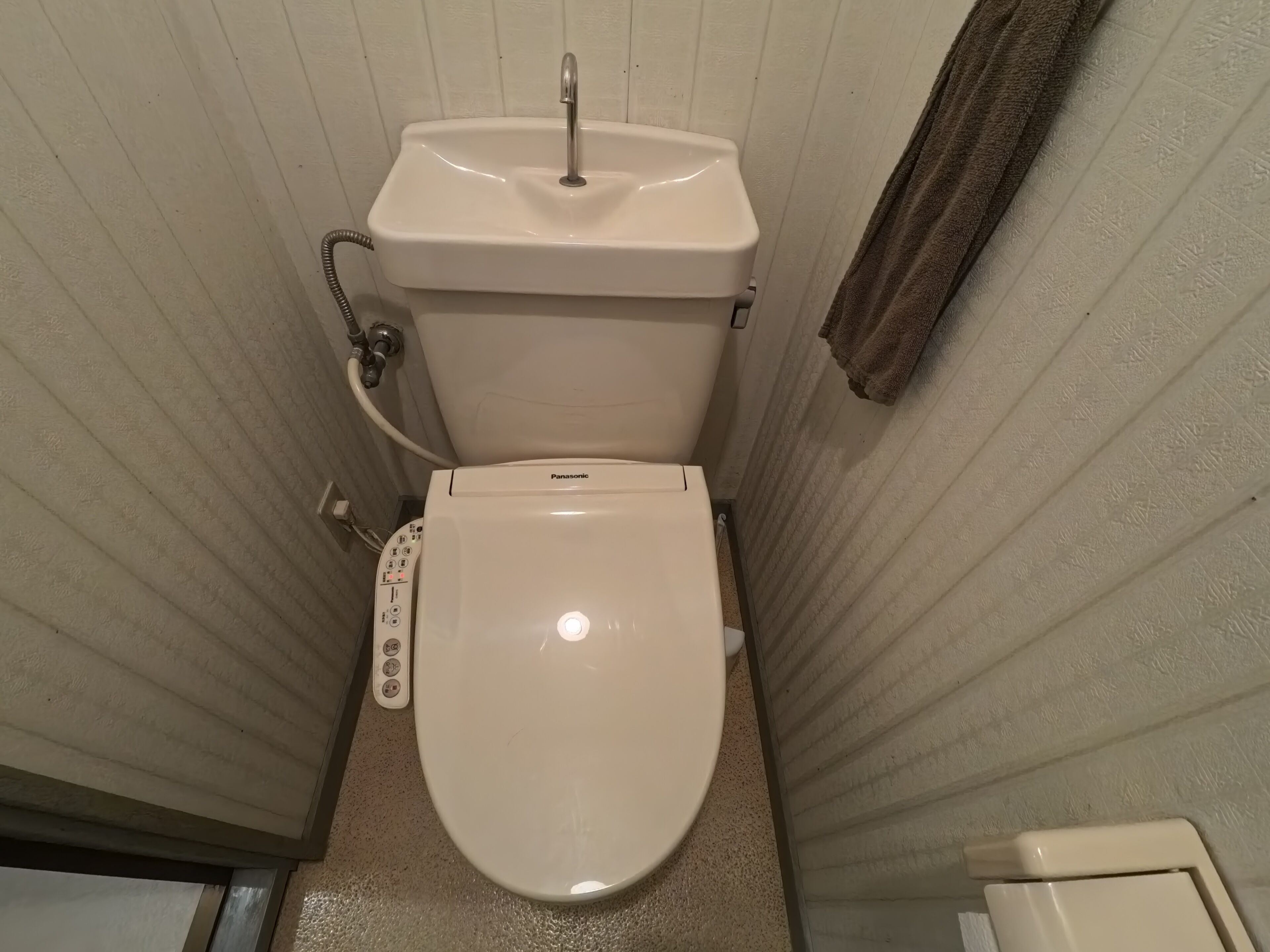A bathroom with a white toilet, a sink, and a shower.