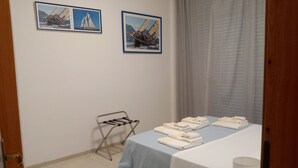 A hotel room with a bed, a chair, a towel rack, and two framed pictures on the wall. - Le Barchette 5 - piano terra (Lecce)