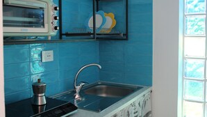 Eine Küche mit blauen Fliesen, einem Vintage-Toaster, einer modernen Spüle und einer Kaffeemaschine.
