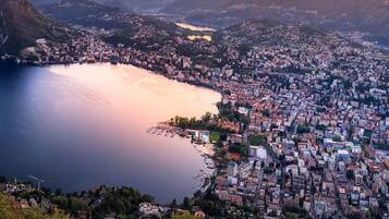 Un paysage urbain côtier avec une vaste étendue d’eau, une zone urbaine densément peuplée et des collines environnantes.