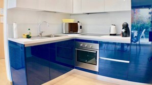 A modern kitchen with a built-in oven, a microwave, and a sink.
