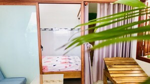 A room with a bed, a small table, a sofa, and a wooden bench. - HOANG BAO VY (Phu Quoc)