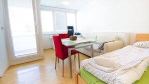 A room with a bed, a desk, a chair, and a window. - City centre studio with a balcony (Ljubljana)