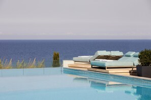Una piscina infinita con vista despejada al océano.