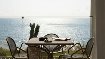 Uma mesa com cadeiras e vista para o mar.