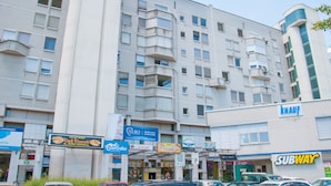 A multi-story building with various commercial establishments on the ground floor, including a Subway restaurant. - Dunajska Apartment (Ljubljana)