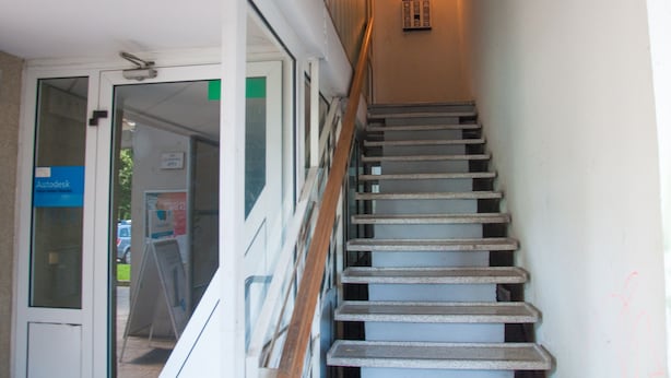 A staircase with a handrail leading to a landing. - Dunajska Apartment (Ljubljana)