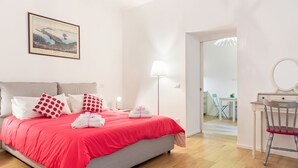 Une chambre à coucher comprenant un lit, une table de chevet, une lampe, une chaise et un bureau avec un miroir.