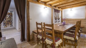 A wooden dining table with chairs, a chandelier, and a wine rack in the background. - Gorizia Sweet Minihouse with Parking (Gorizia)