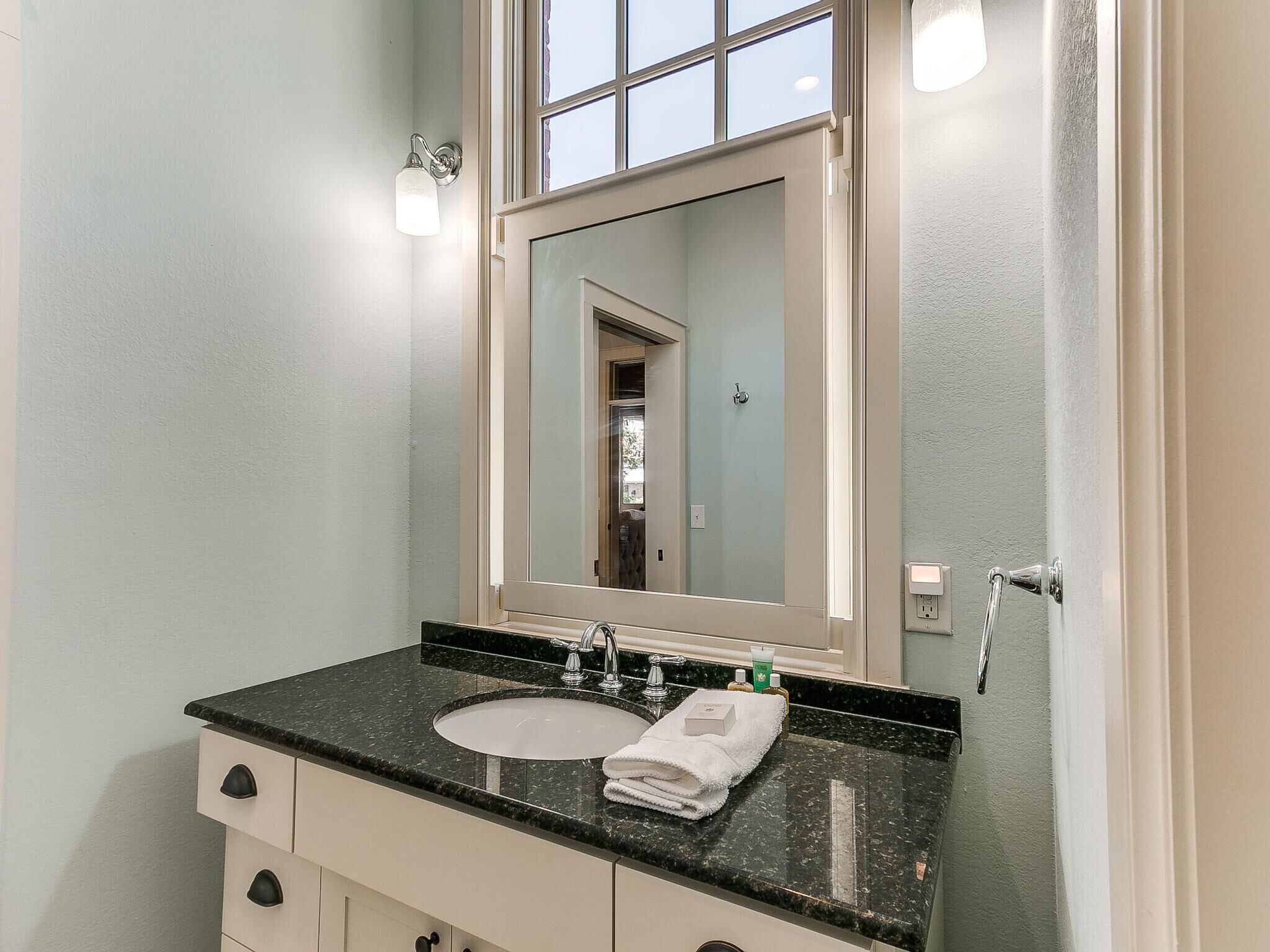 Une salle de bain avec un lavabo, un miroir et un meuble de rangement.