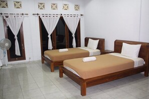 A room with two wooden beds, white curtains, a standing fan, and a tiled floor. - Dono Guest House (Ubud)