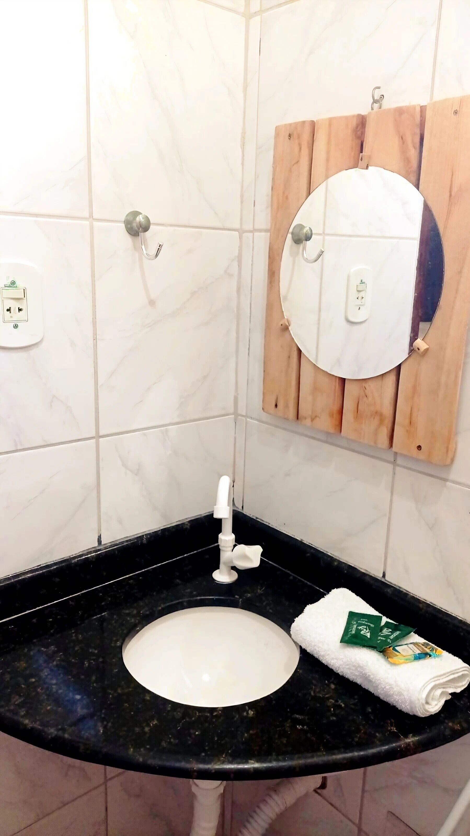 A bathroom with a black countertop sink, a white mirror, and a towel.