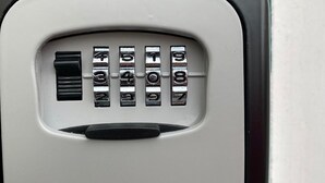 Un clavier numérique avec les chiffres de 1 à 9 et le chiffre 0, ainsi qu’une touche noire sur un panneau blanc.