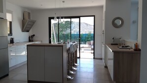 A modern kitchen with a central island, stainless steel appliances, and a view of the outdoors. - Pretty stone house with swimming pool near Gordes (Gordes)