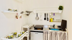 A compact kitchenette with a built-in oven, a sink, and a dish rack. - San Nicola Casa Clemente Apartment (Bari)