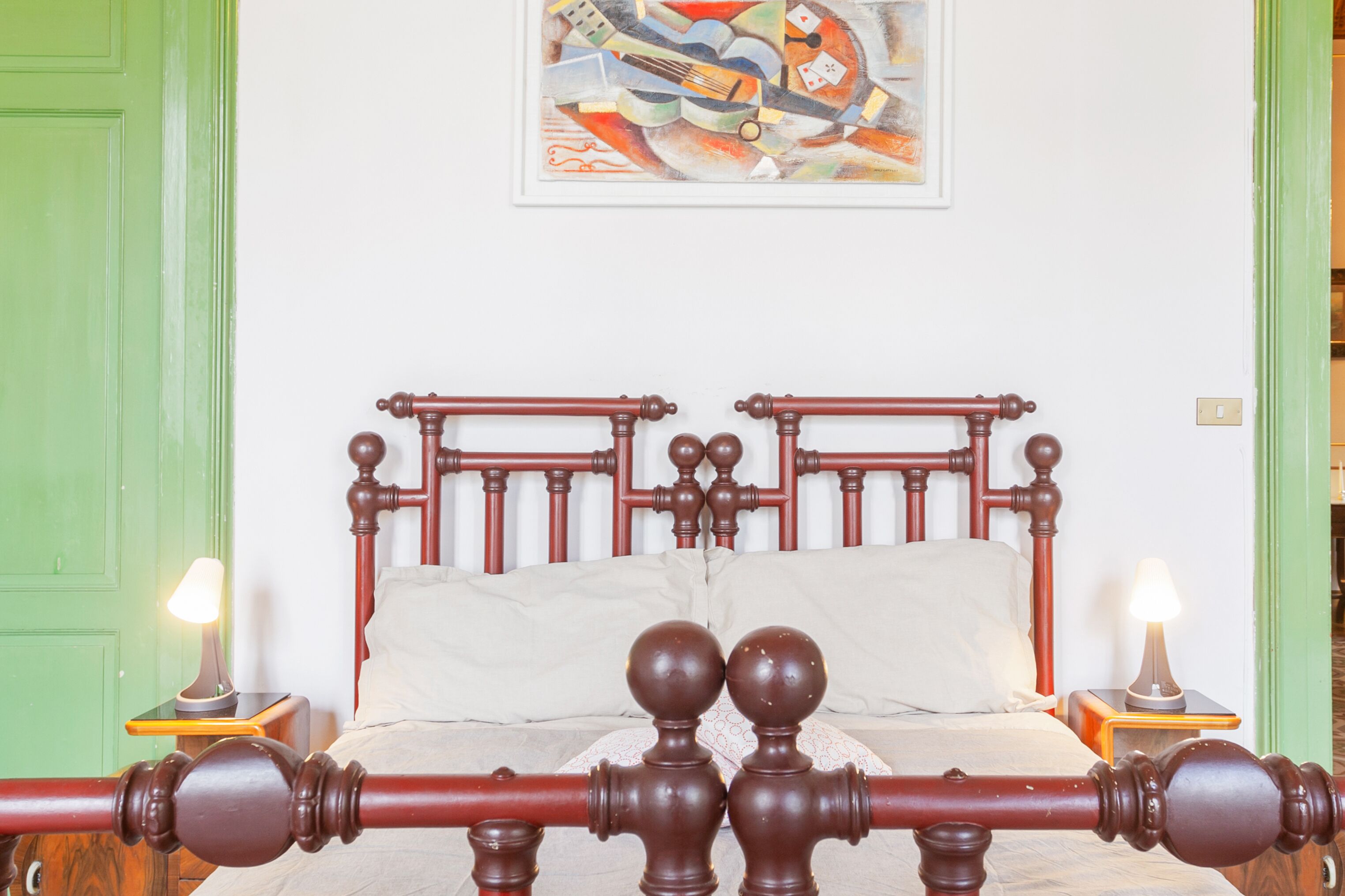 A bed with a wooden frame and two nightstands with lamps.
