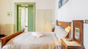 A bedroom with a bed, bedside lamp, and a mirror. - La terrazza sulla Chiesa di San Francesco d'Assisi (Castellana Grotte)