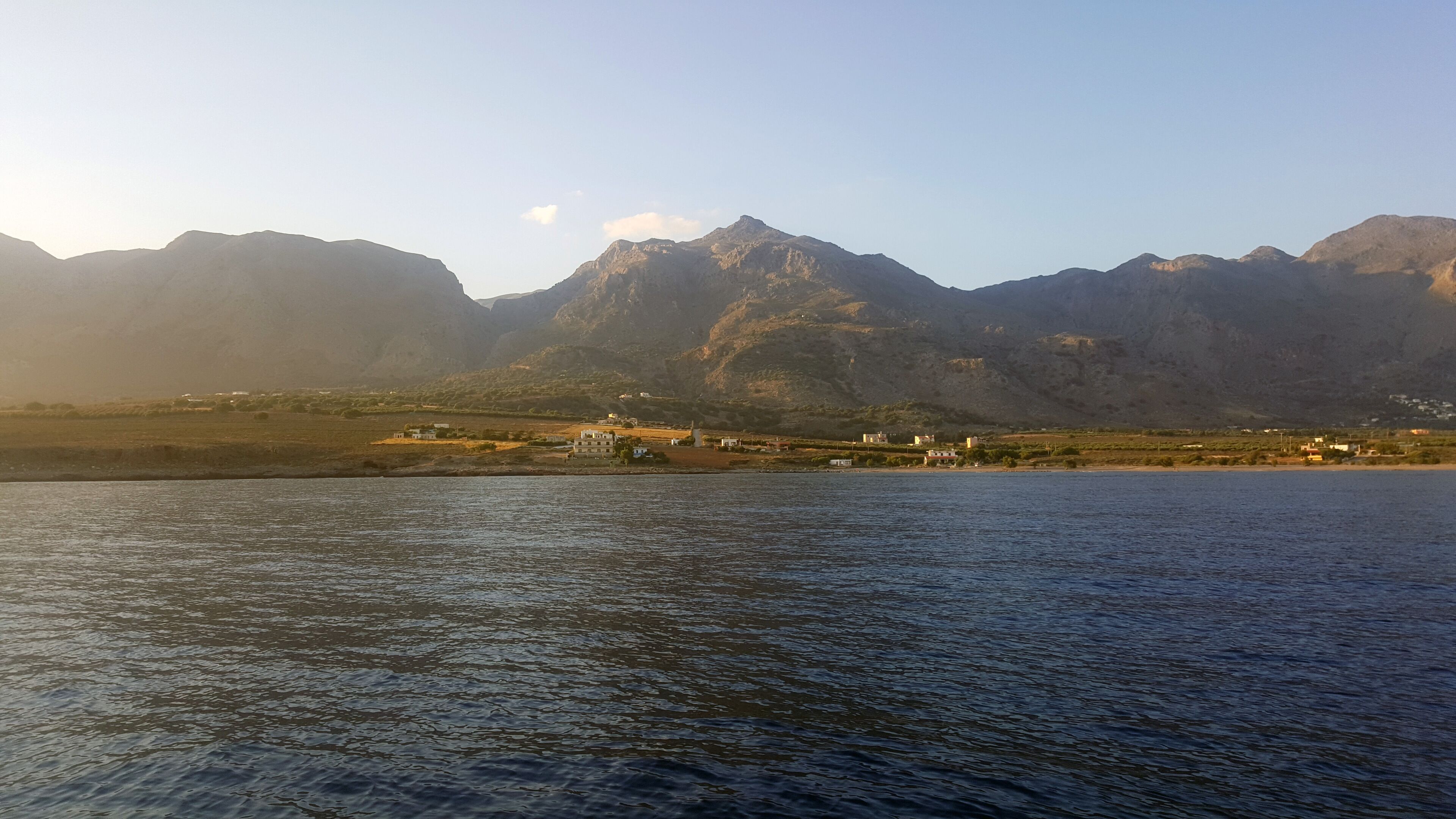 A coastal town with a view of mountains in the background.