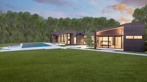 Una casa moderna con piscina, amplias ventanas y un césped bien cuidado.