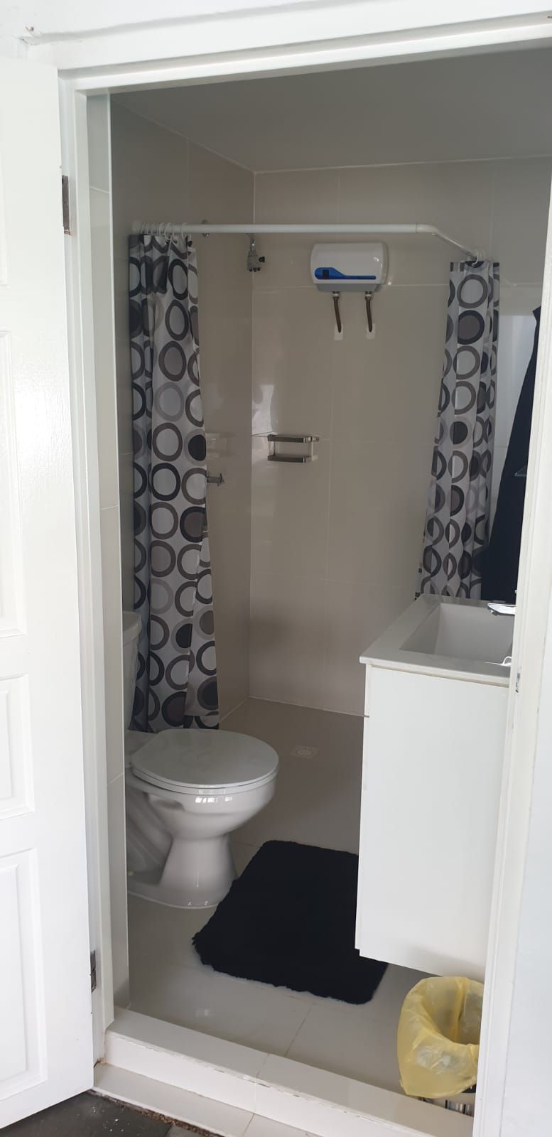 Une petite salle de bain comprenant des toilettes, un lavabo et un espace douche.